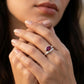 Close-up editorial lifestyle portrait of a model showcasing a modern marquise-cut ruby statement ring on her hand.