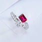 Three-quarter studio product profile focusing on the open-band architecture of a modern ruby and white sapphire Toi et Moi ring.