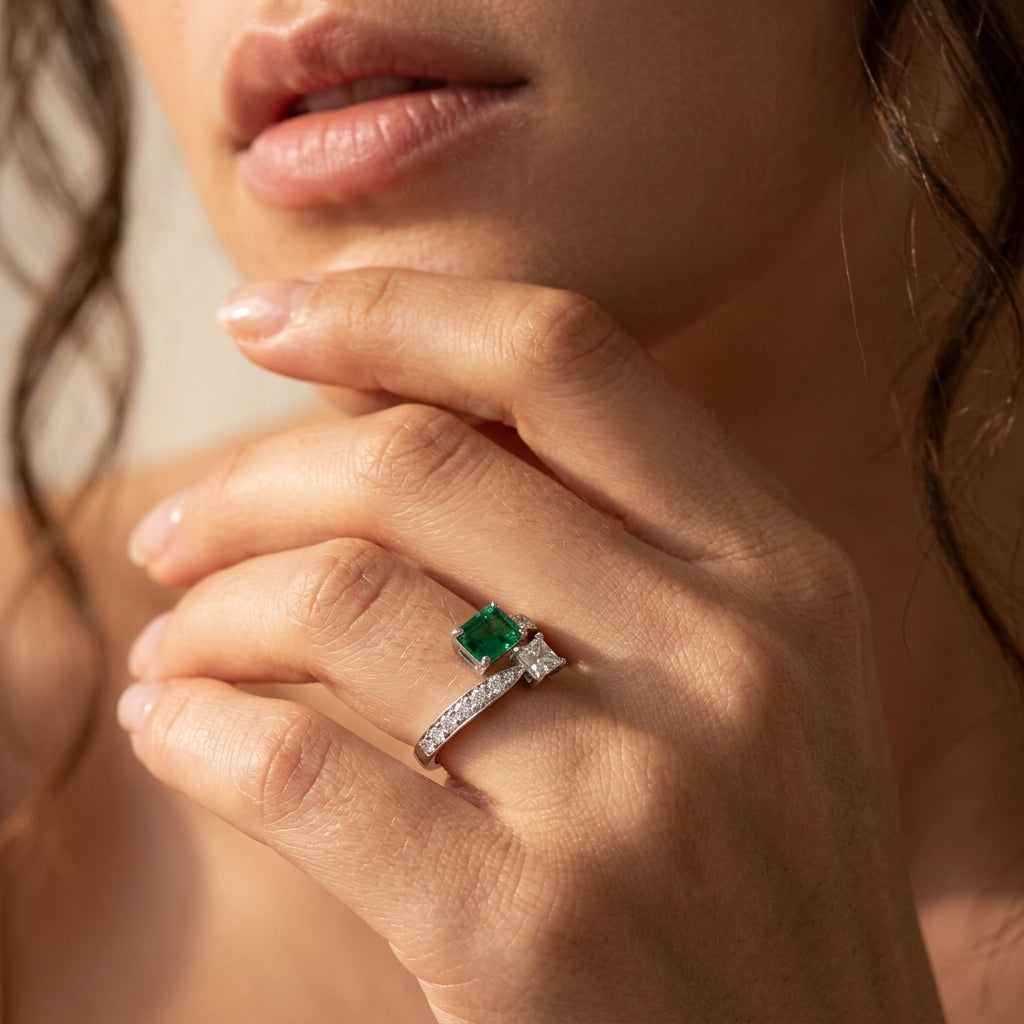 Close-up editorial portrait lifestyle view of a model displaying a modern two-stone emerald Toi et Moi ring.