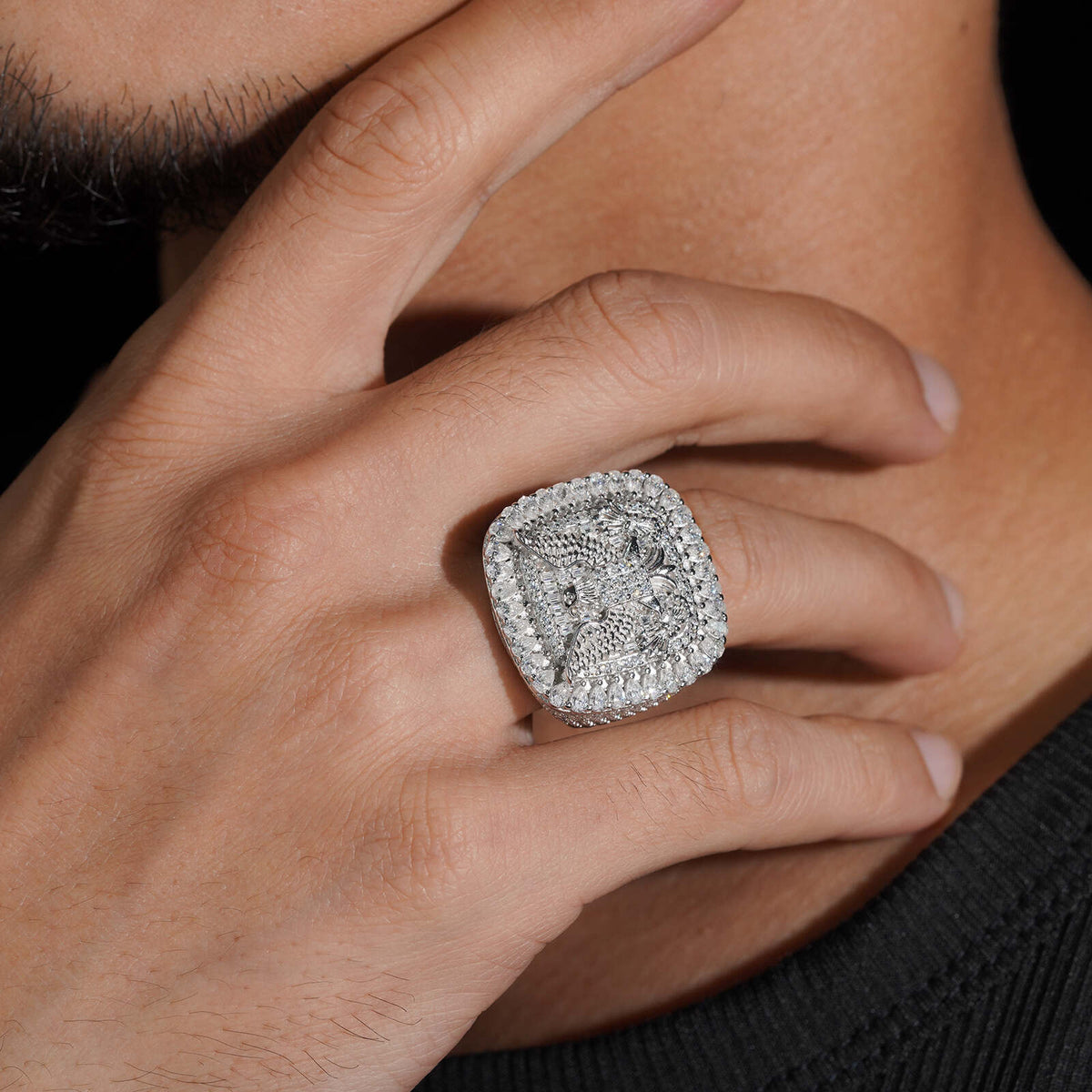 Model wearing S925 sterling silver iced out moissanite eagle cushion ring touching neck   