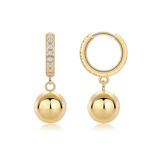 Gold pavé moissanite huggie hoop earrings with dangling polished gold ball charms on white background.