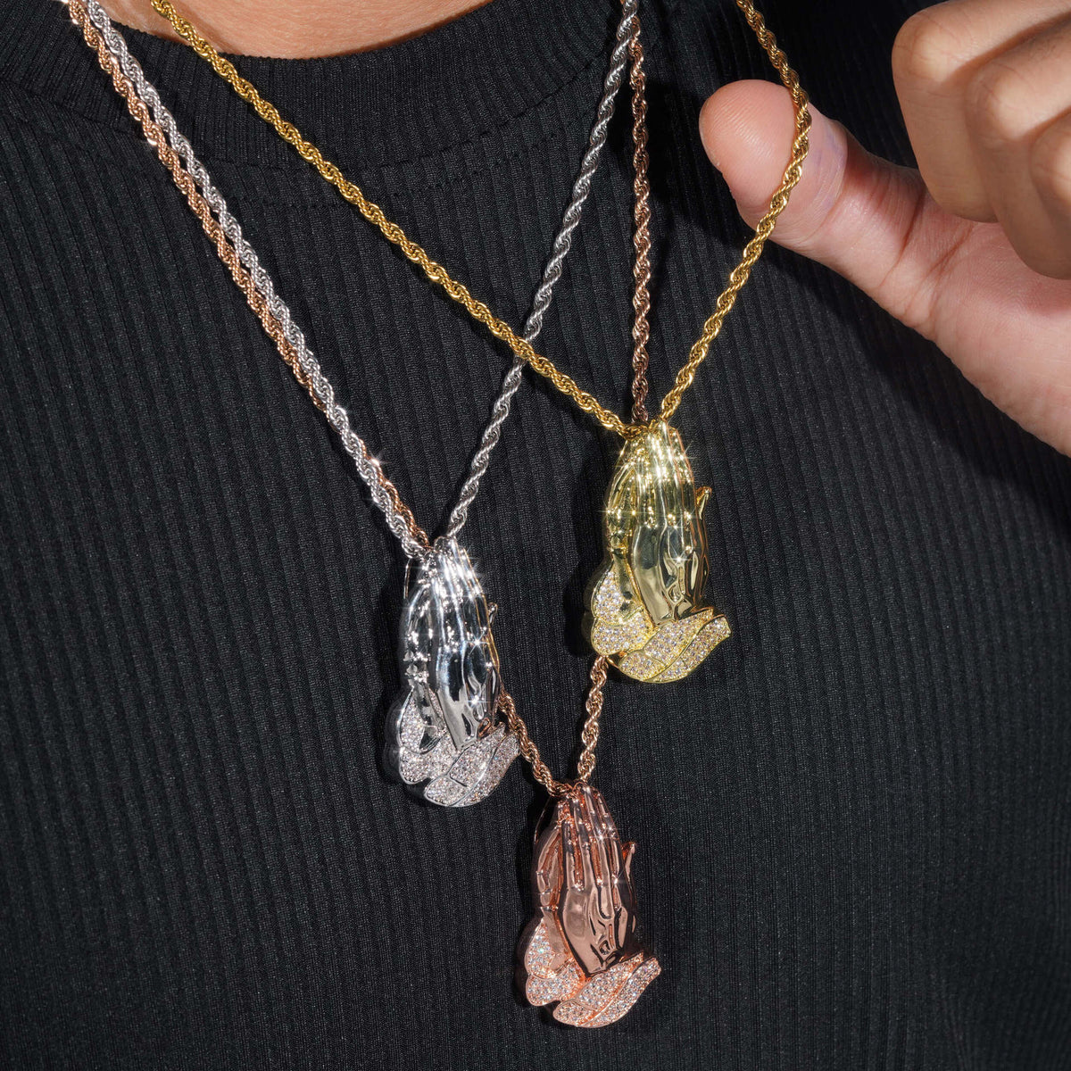 Model wearing layered S925 silver iced out moissanite praying hands pendant necklaces