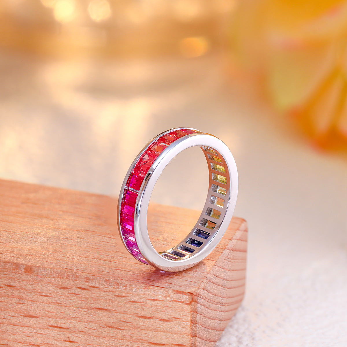Side view of multi-color baguette cut gemstone channel set eternity ring.