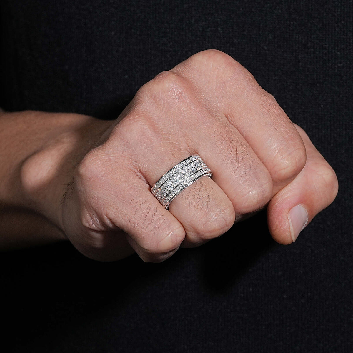 Close up view of person wearing multi row micro pave moissanite wide eternity band ring