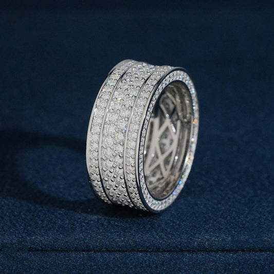 Multi row micro pave moissanite wide eternity band ring in sterling silver resting on dark blue box