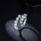 Dramatic sparkler view of mixed cut moissanite cluster open ring under lighting.