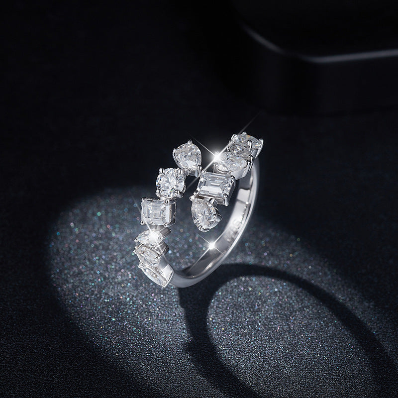 Dramatic sparkler view of mixed cut moissanite cluster open ring under lighting.