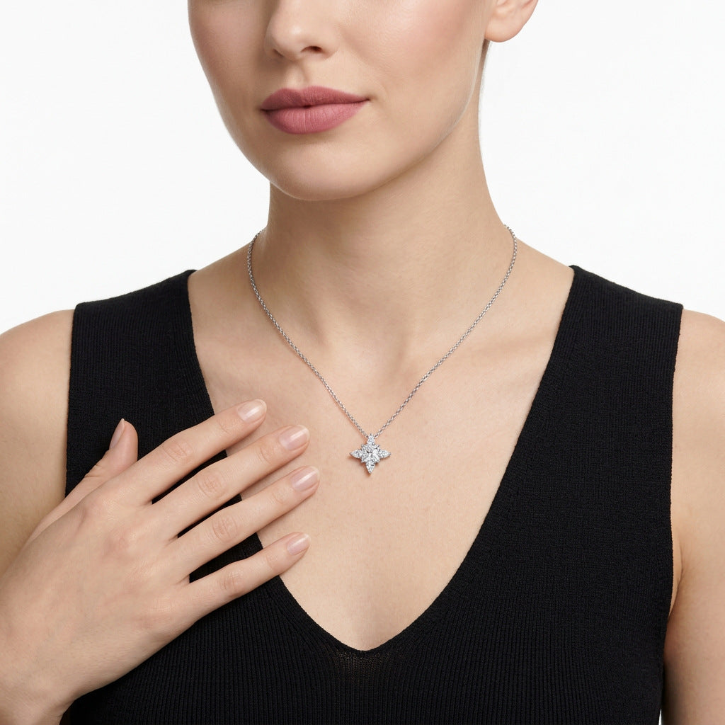 Close-up view of multi-shape moissanite compass star pendant necklace styled with black outfit.