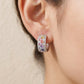 Model wearing multicolor baguette gemstone and moissanite wide huggie hoop earring on earlobe