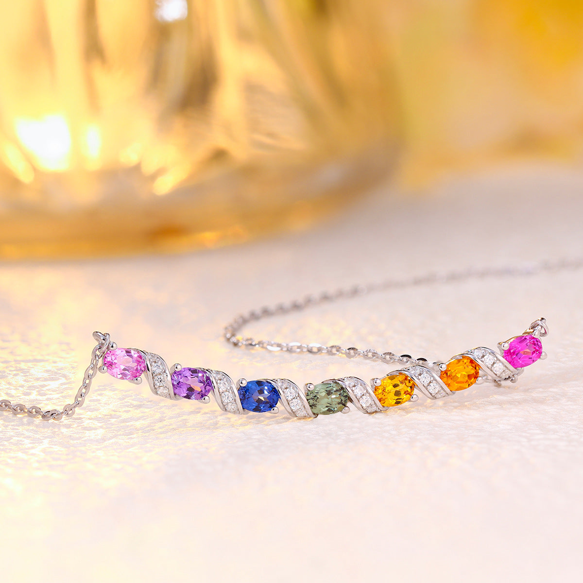 Angled perspective view of multicolor gemstone and moissanite rainbow bar necklace on white surface