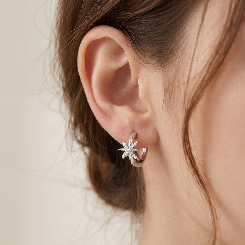Close-up view of a model wearing north star moissanite huggie hoop earring.