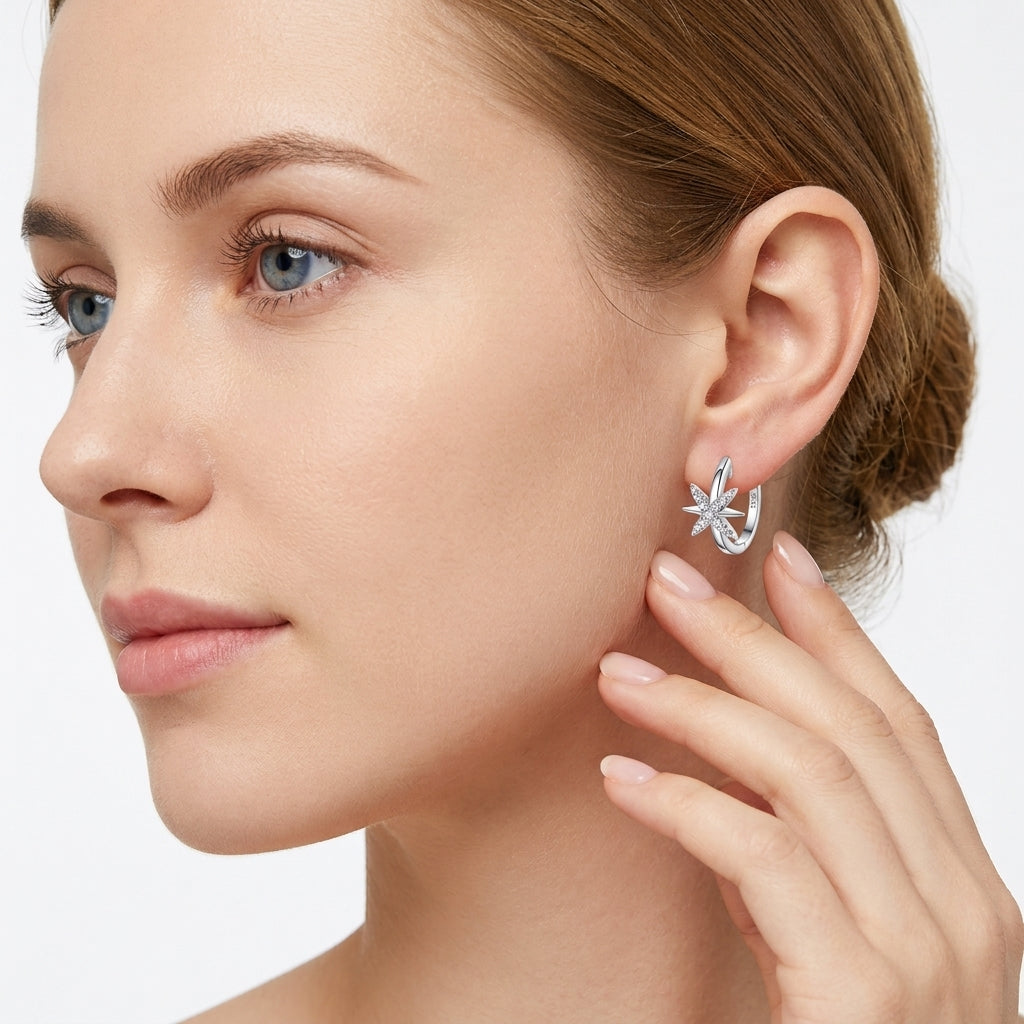 Model showing celestial north star moissanite huggie hoop earrings on ear.