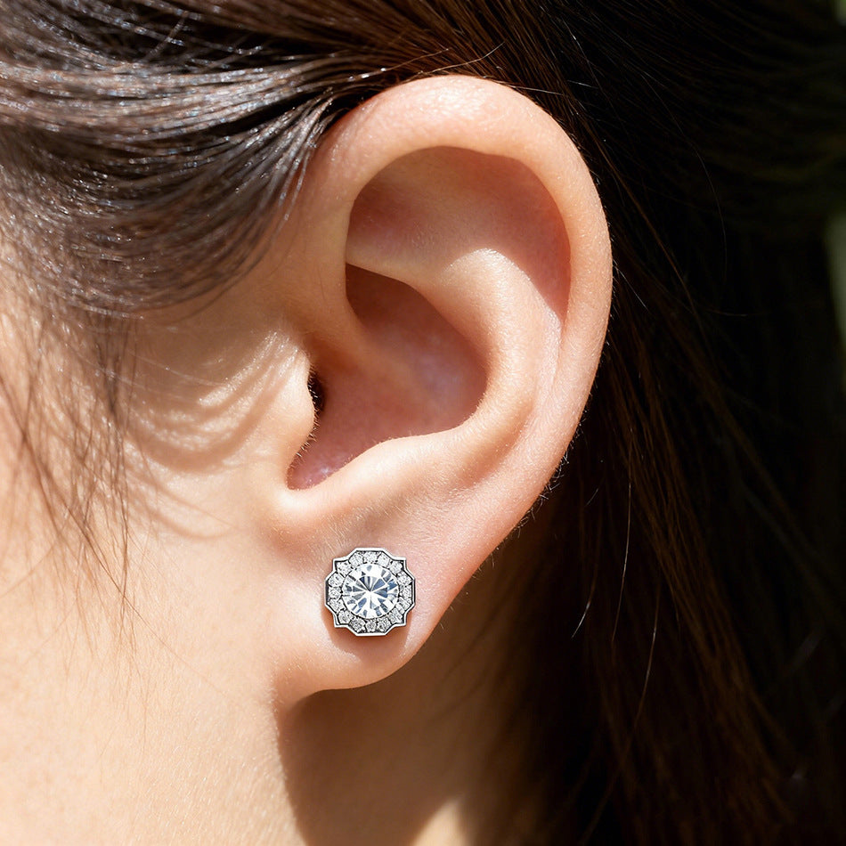 Model wearing vintage octagonal scalloped halo lab diamond stud earring on earlobe.