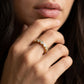 Editorial lifestyle wear portrait of a model showcasing an old money aesthetic moissanite bubble stacking band in a gold tone.