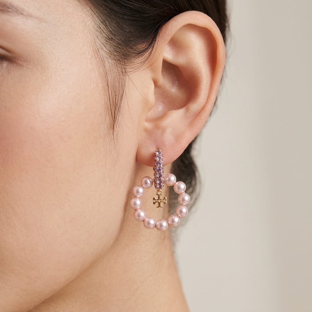 Close up lifestyle view of a model showcasing old money aesthetic moondance pearl drop earrings with logo charms.