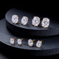 Oval cut lab diamond stud earrings in yellow and white gold displayed on dark multi-tier stand