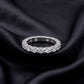 Perspective view of oval cut lab-grown diamond eternity band ring on dark silk.