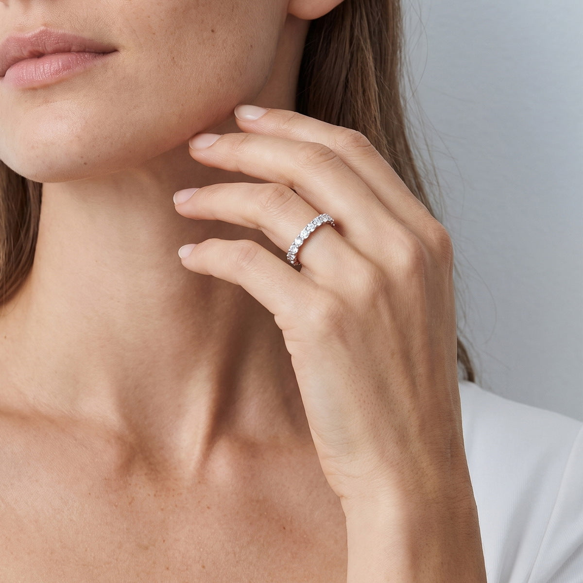 Model wearing oval cut lab-grown diamond eternity band ring.