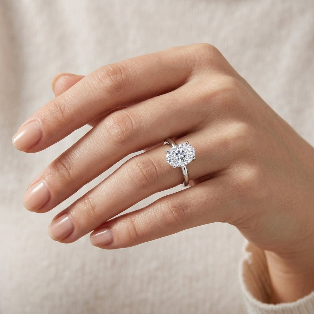 Model wearing oval cut lab grown diamond minimalist plain solitaire ring.