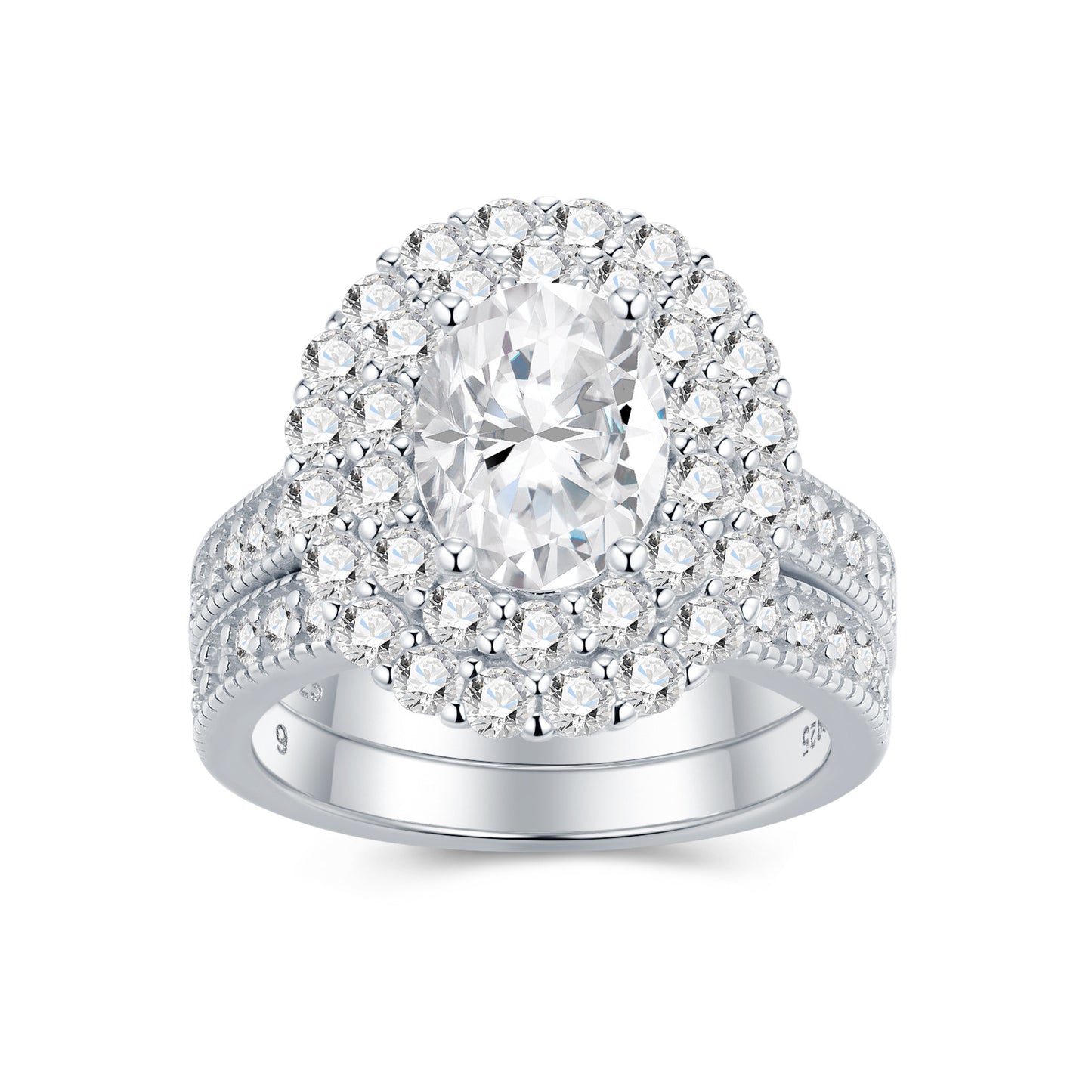 Oval cut moissanite double halo bridal ring set with matching milgrain wedding band on white background.