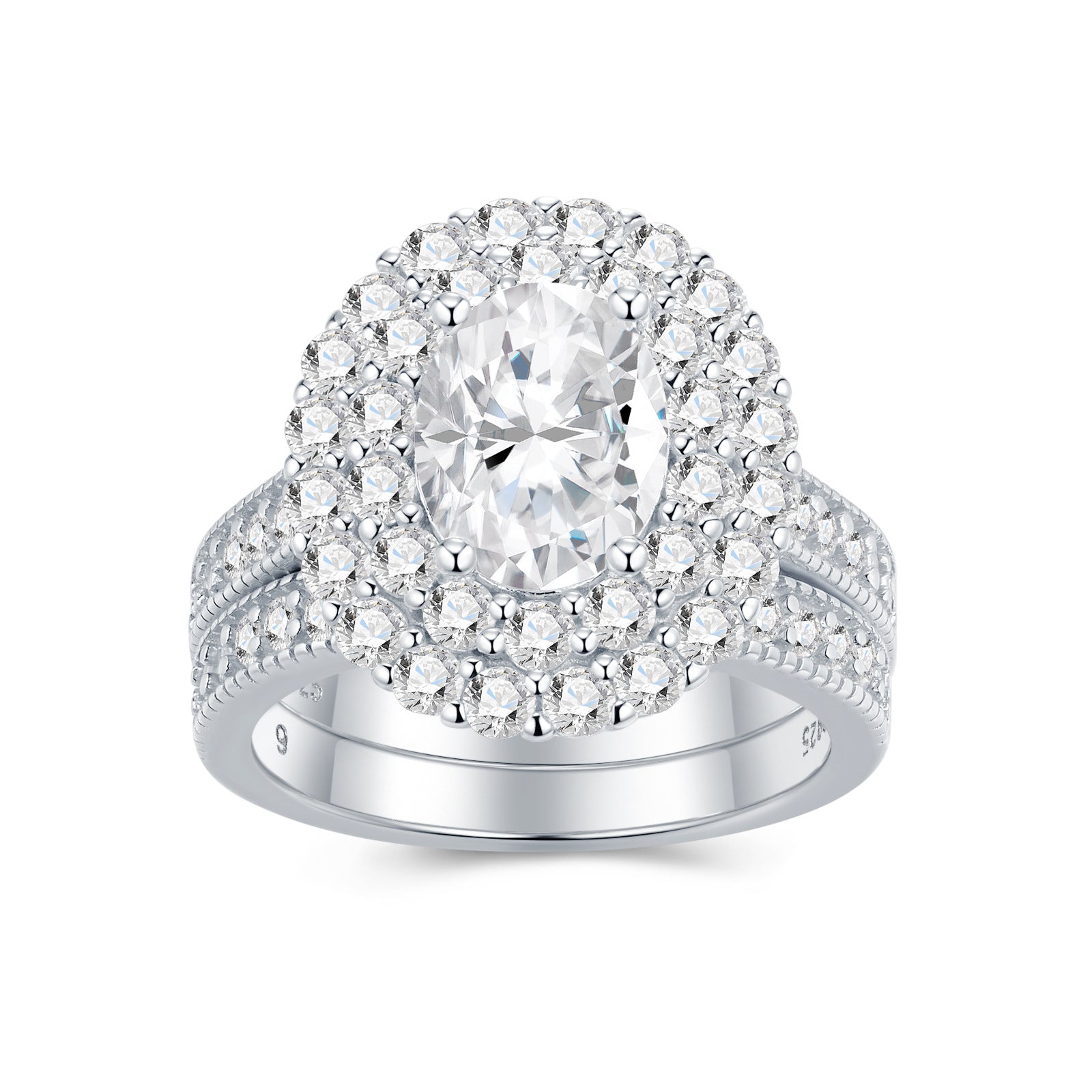 Oval cut moissanite double halo bridal ring set with matching milgrain wedding band on white background.