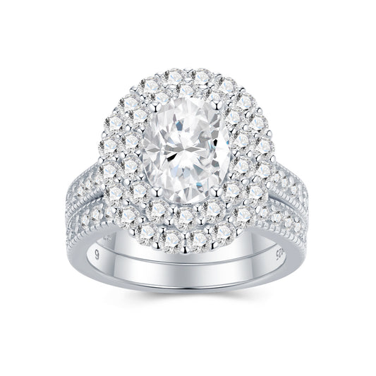 Oval cut moissanite double halo bridal ring set with matching milgrain wedding band on white background.