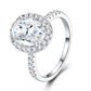 Silver oval cut moissanite engagement ring with micro-pave halo and pave shank on white background.