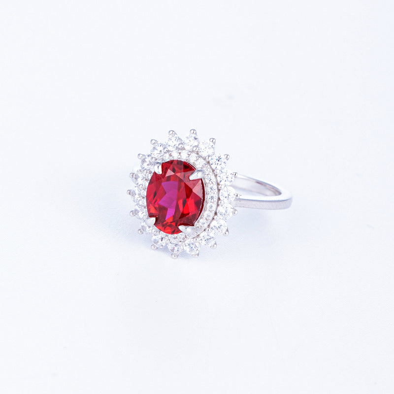 Side profile view of a pair of ruby Diana halo stud earrings on display steps.