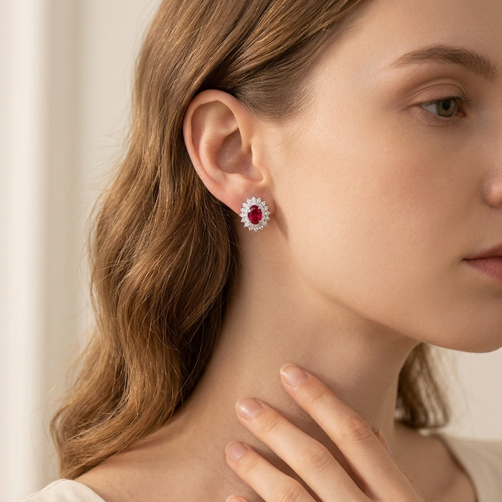 Close-up of a woman wearing a red gemstone earring with a neutral background