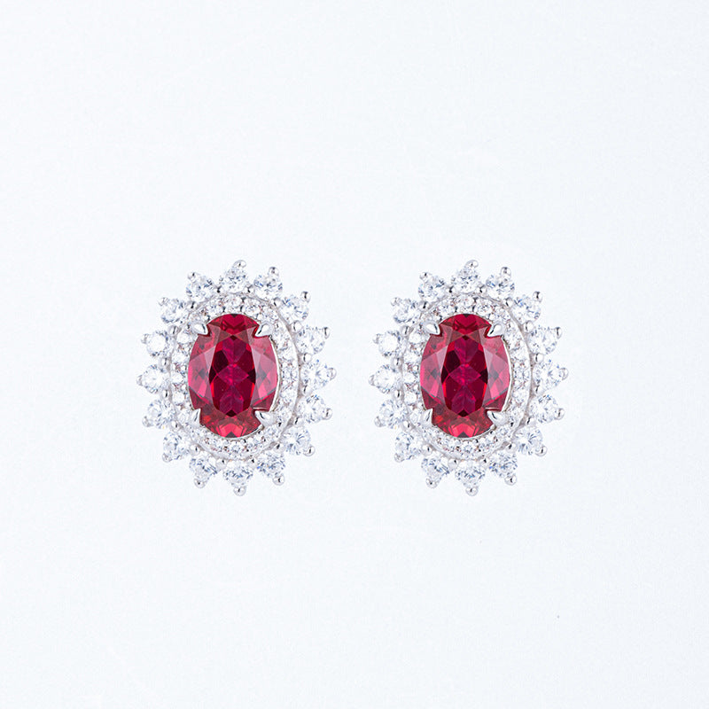 Classic oval-cut ruby Diana halo stud earrings in brilliant sterling silver cluster setting.