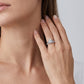 Angled perspective shot of oval engagement ring stacked with curved pave accent wedding band.