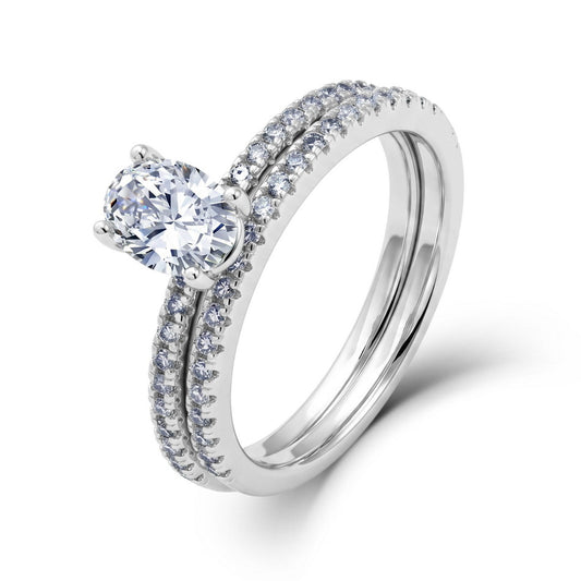 Perspective view of oval lab diamond solitaire ring and matching micro pave band in platinum plated silver.