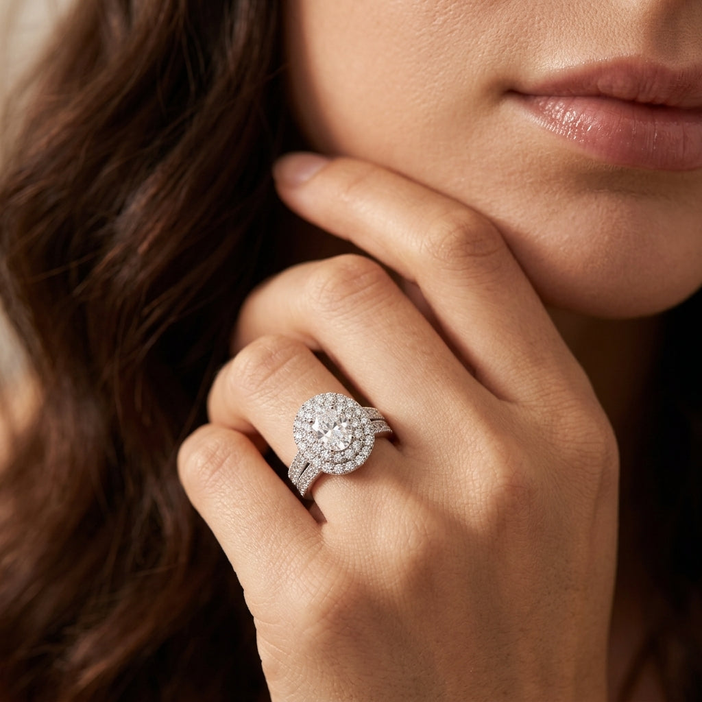 Close-up view of a model wearing an oval cut moissanite double halo bridal set.