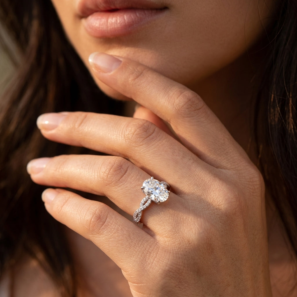 Close-up of a model wearing oval cut moissanite twisted vine infinity engagement ring.