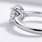 Macro side profile showing 4-prong basket setting and polished shank on oval moissanite ring.