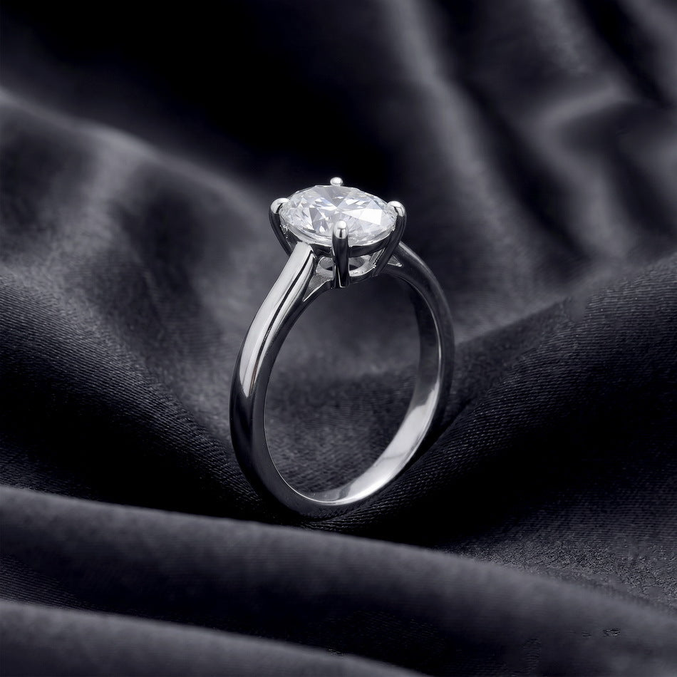 Side basket view of oval lab grown diamond plain band solitaire ring on dark silk.