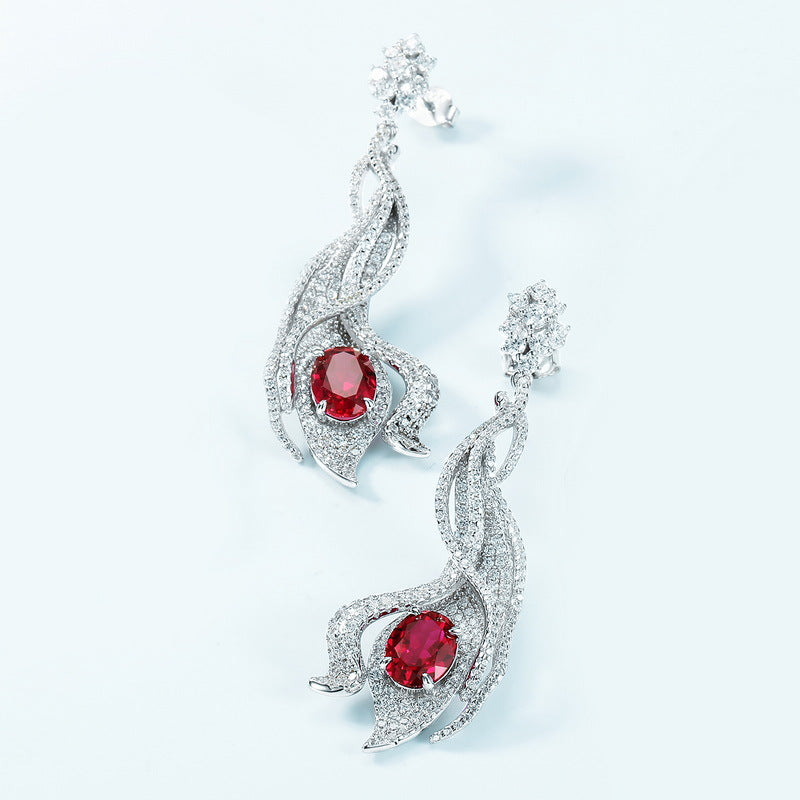 Close-up of 4.6ct oval-cut crimson ruby earrings, showcasing immaculate mirror-polish finish