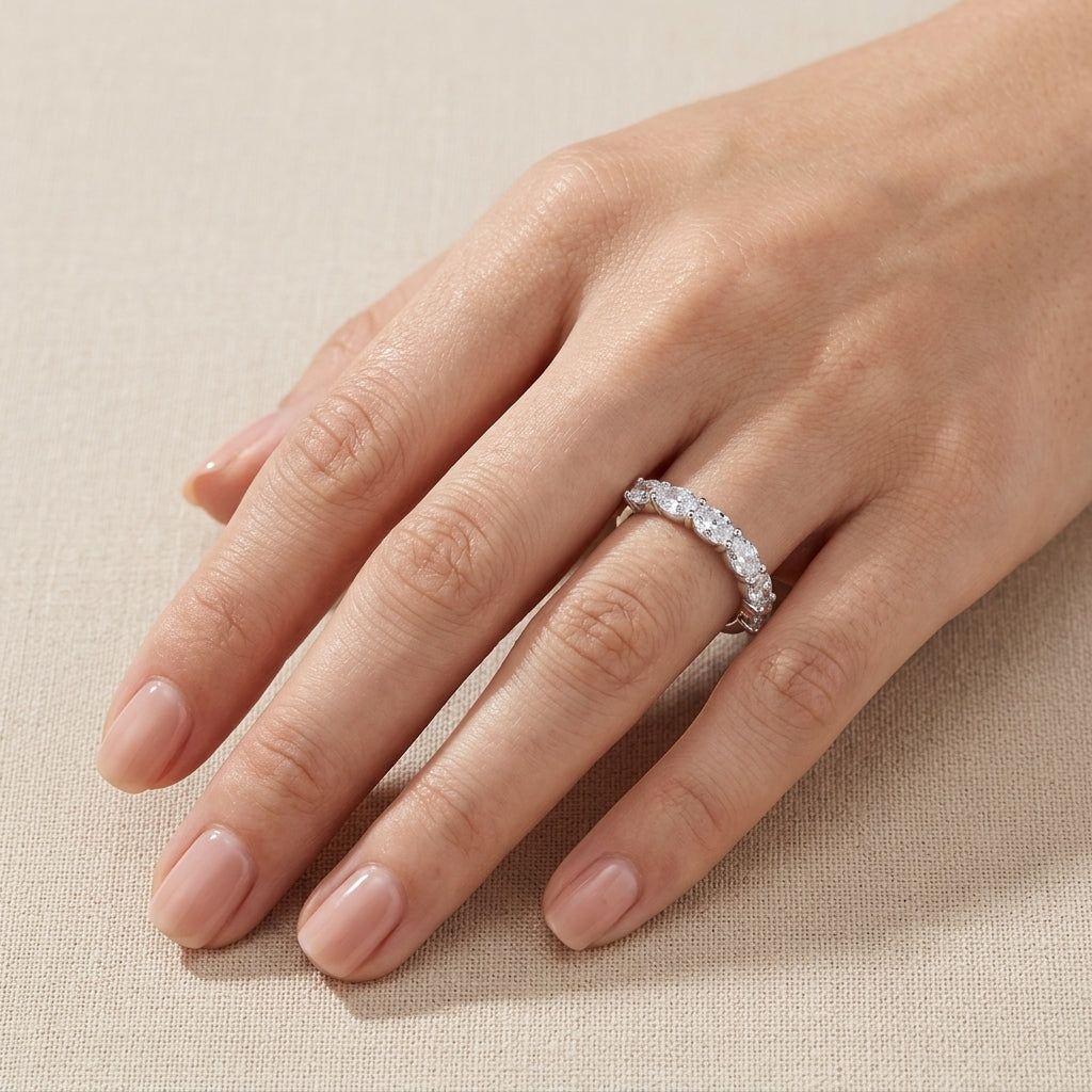 Full hand shot of model displaying oval seven-stone shared-prong stacking ring.