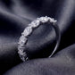 Angled perspective view of oval seven-stone wedding band resting on dark silk.