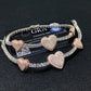 Pave heart moissanite tennis bracelets with rose gold heart motifs on dark background