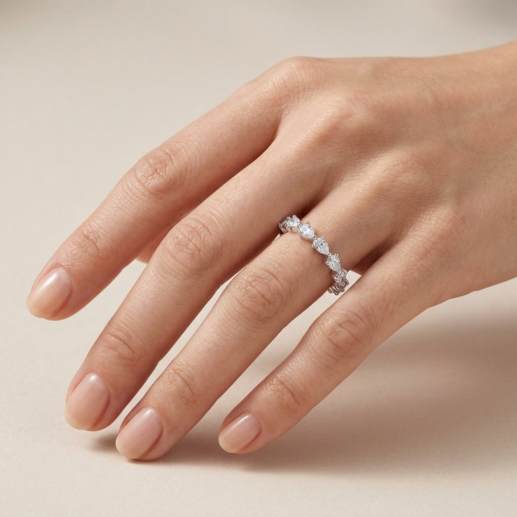 Close-up shot of model hand wearing pear cut 2.5x4mm lab grown diamond eternity ring.
