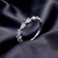 Perspective shot of pear cut 2.5x4mm lab diamond half eternity wedding band on black silk background.
