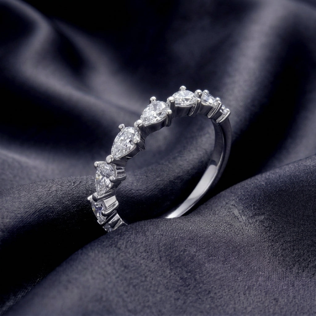 Perspective shot of pear cut 2.5x4mm lab diamond half eternity wedding band on black silk background.