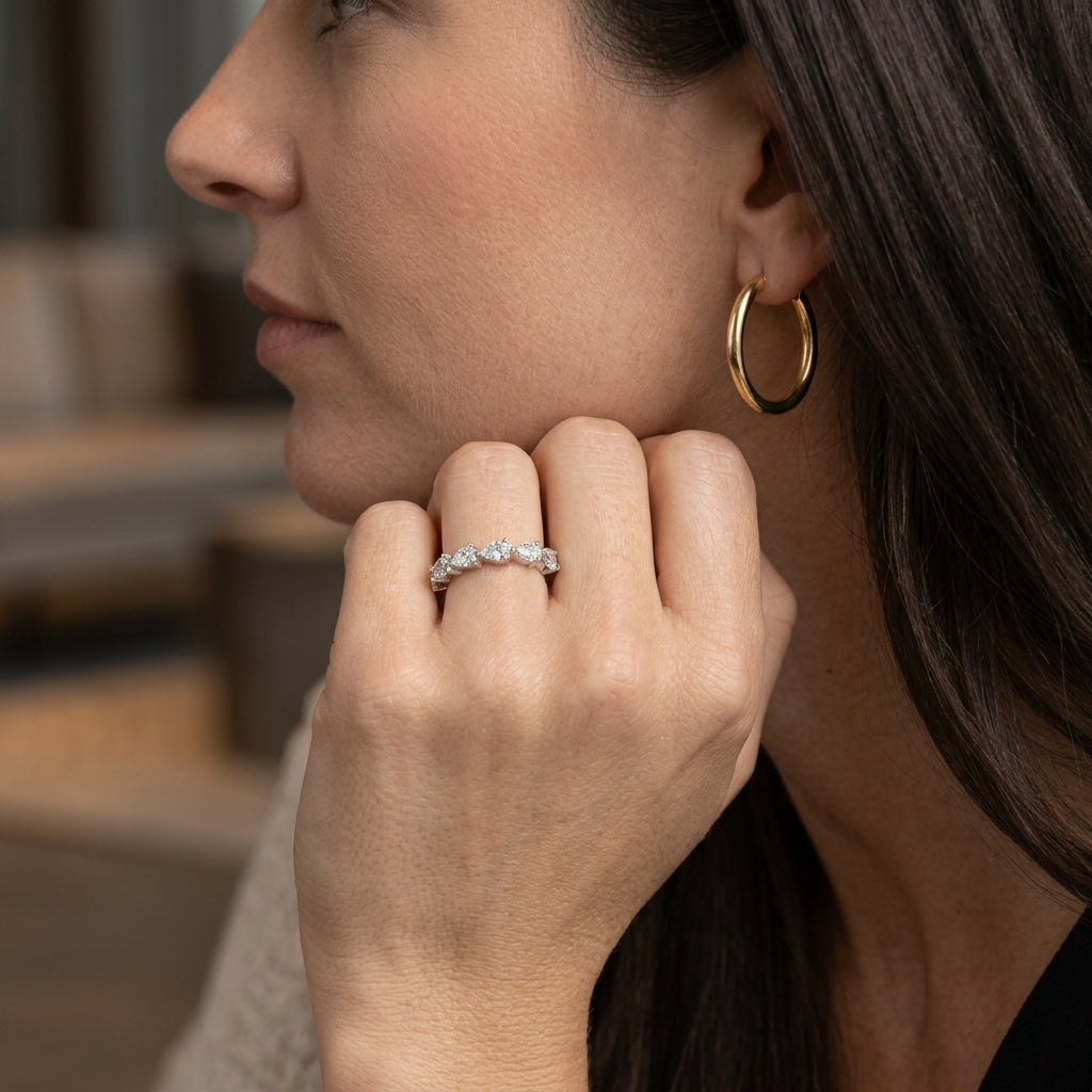 Model wearing pear cut 2.5x4mm lab grown diamond half eternity ring on ring finger.