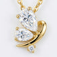 Macro close-up showing two pear-cut moissanite wings and fluid gold curve on butterfly pendant.