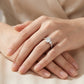 Model showing pear cut moissanite toi et moi ring on hand in warm ambient lighting.