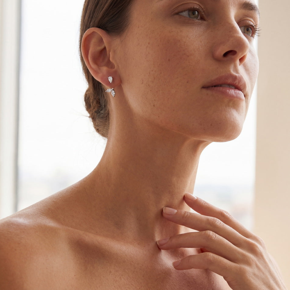 Model wearing pear and marquise cut diamond botanical leaf ear jacket earrings.