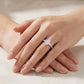 Model wearing pear cut moissanite engagement ring with baguette accent pave band in soft natural light.