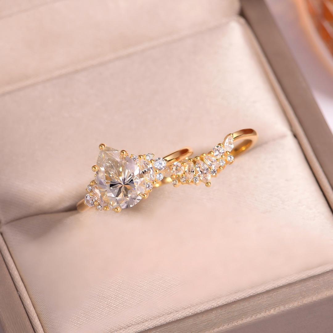 Perspective view of 18K gold plated pear cut moissanite cluster solitaire ring in box.