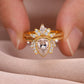 Close-up view of gold pear cut lotus halo solitaire with matching sunburst crown band held in hand.